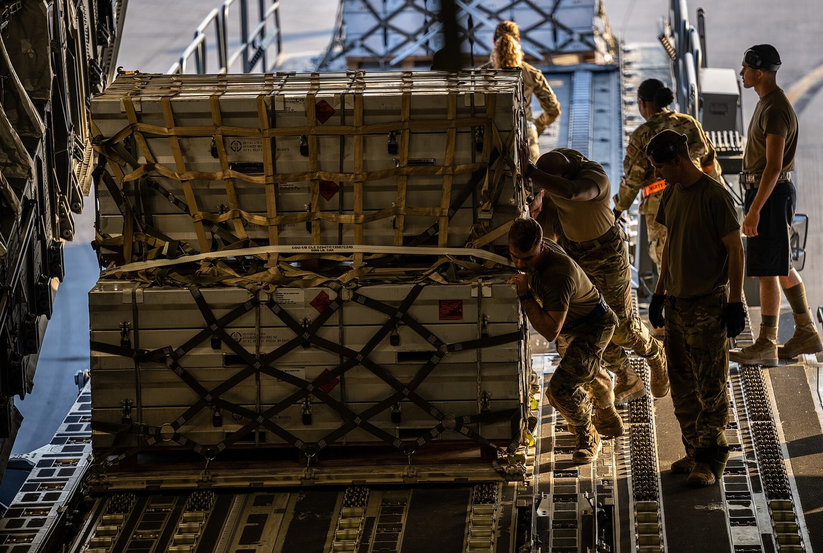 Airmen loading palletized cargo aboard a C-17 Globemaster III transport aircraft